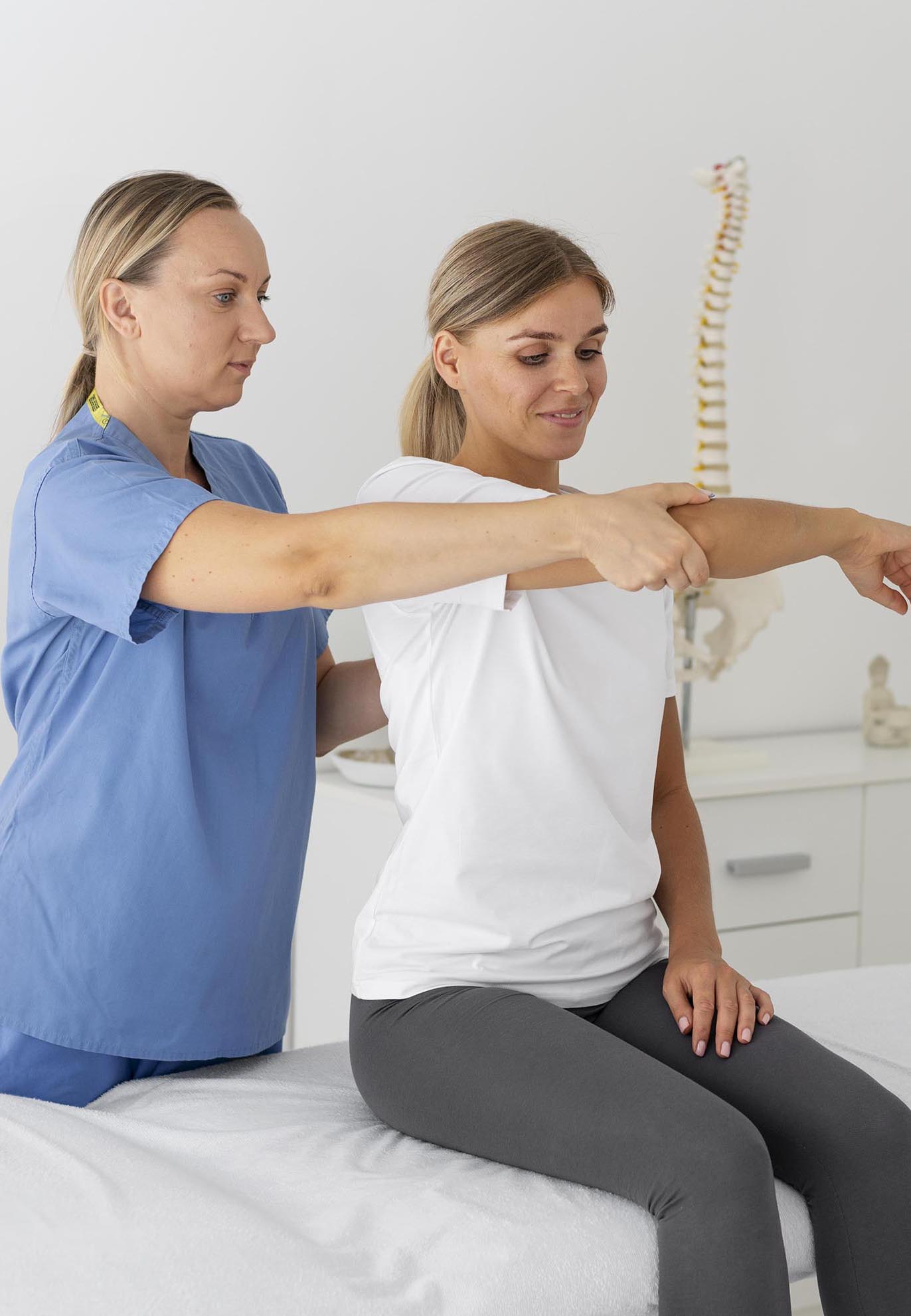 physiotherapist helping female patient her clinic 1 1